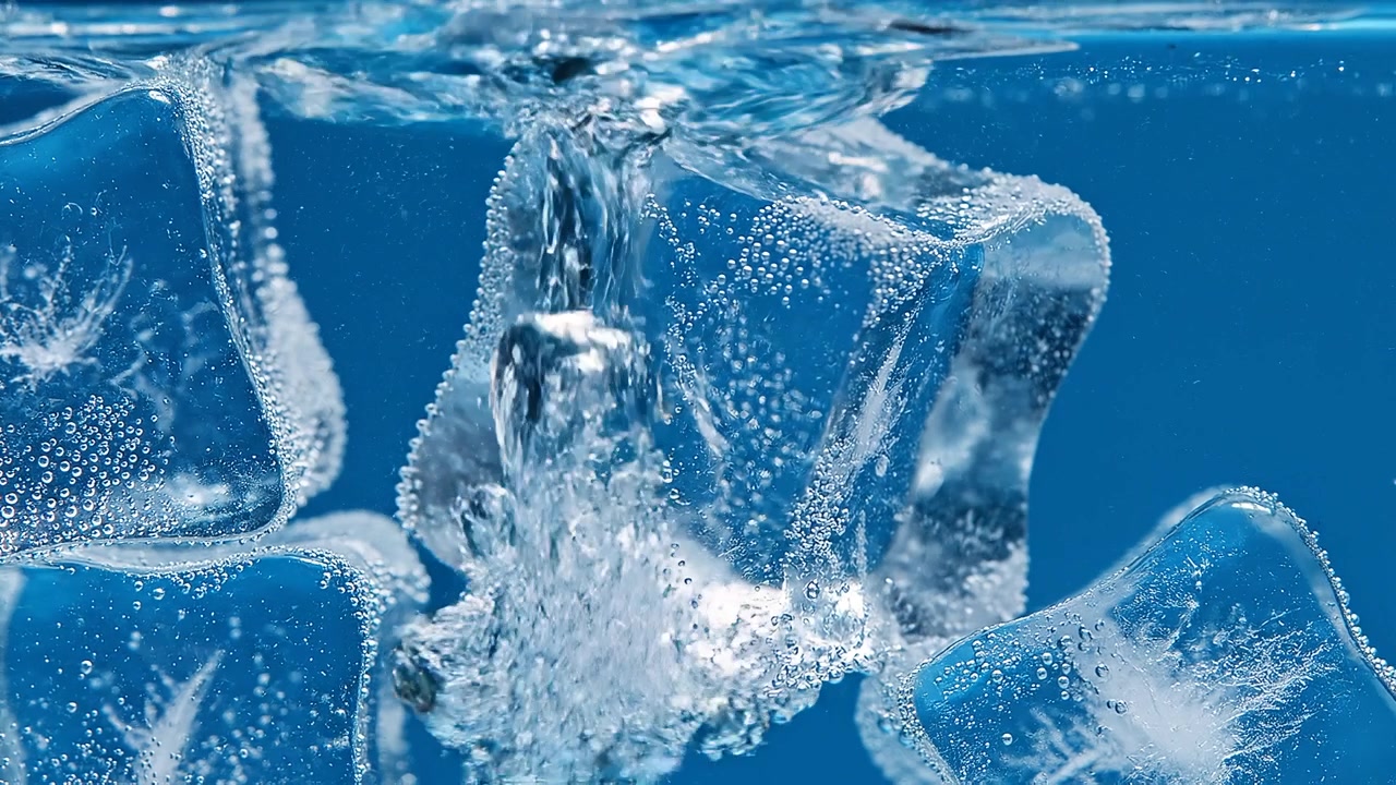 Macro shot of ice cubes submerged in carbonated blue water