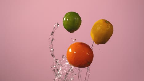 citrus fruit falling in slow motion against pink background