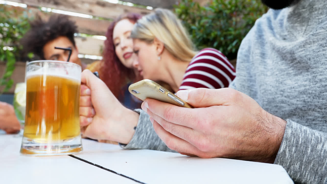 4k 음료를 마시면서 휴대폰을 사용하는 친구들