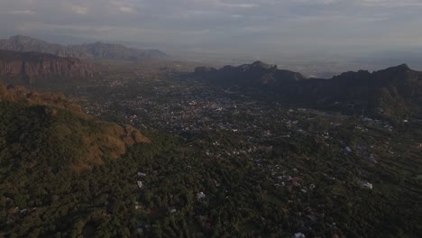 Drone-Aéreo-Vuela-Sobre-La-Ciudad-Del-Valle-De-Tepoztlán-En-Morelos-México,-Paisaje-De-Montaña-Verde-Y-Horizonte,-Pueblo-Mágico