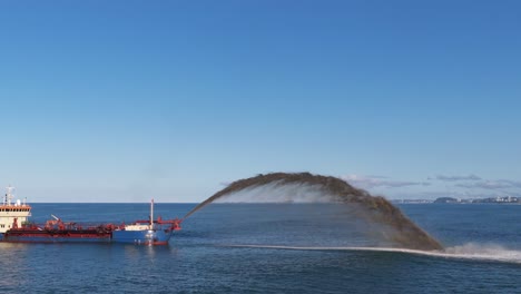 a dredging ship pumps sand to restore cyclone-damaged beaches at surfers paradise, gold coast. clear skies and calm seas