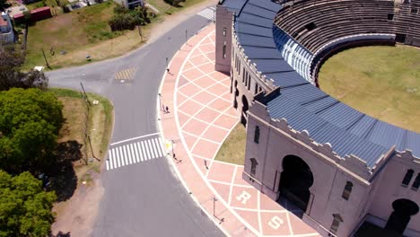 aerial view of a couple of friends walking around the real de san carlos bullring in colonia del sacramento, uruguay on a sunny day