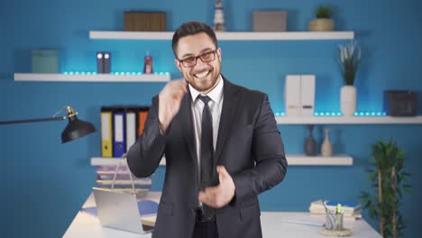 un hombre de negocios feliz aplaudiendo mirando a la cámara.