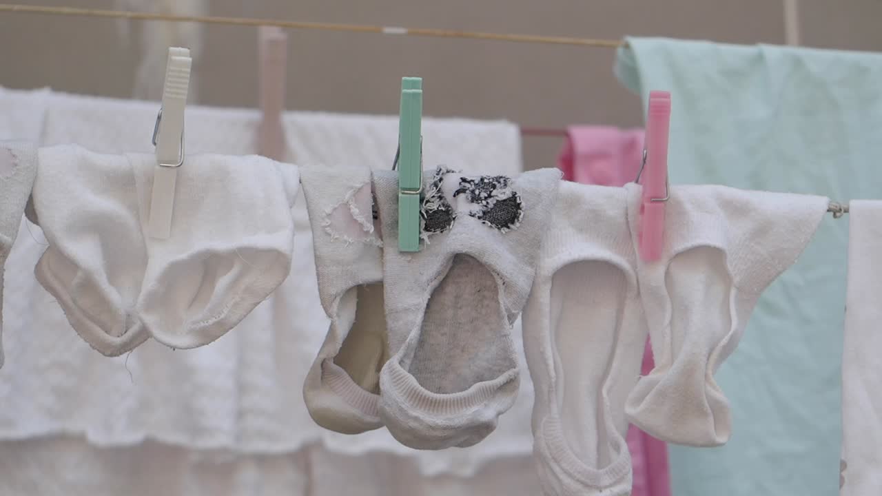 Laundry drying on a clothesline with socks and clothespins
