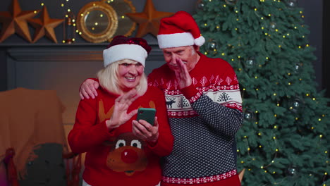 Mature-family-taking-selfie-on-mobile-phone,-communicating-video-call-online-celebrating-Christmas