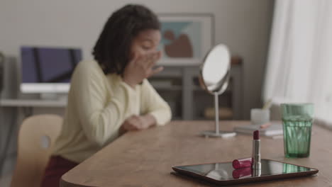 young woman doing makeup at home