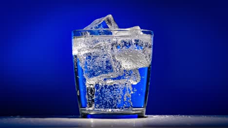 glass of water with ice on a dark blue background