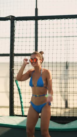 woman in bikini jumping on trampoline