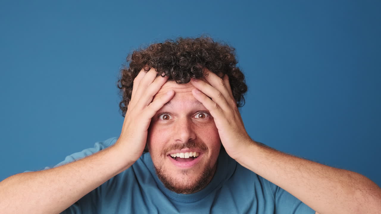 Uomo che reagisce con sorpresa ed entusiasmo su sfondo blu