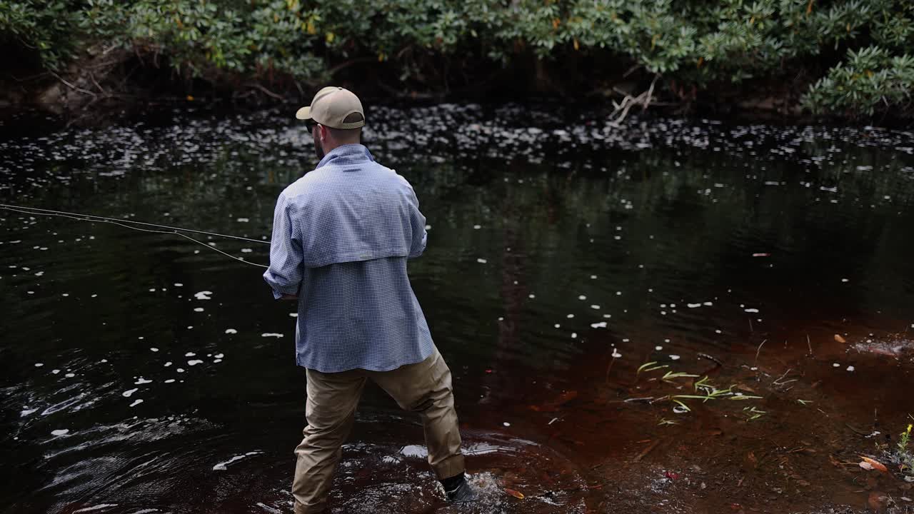 Slow Motion POV over-the-shoulder footage of a Fly Fisherman in the Pocono Mountains in Pennsylvania casting into the stream.