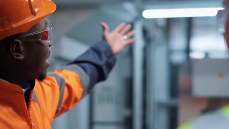 closeup uniformed engineer talking unknown specialist at manufacture company