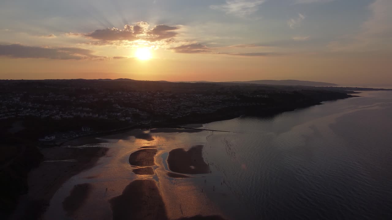 vista aérea de los rayos dorados del atardecer reflejada sobre la costa de la playa exótica romántica deriva lenta a la izquierda