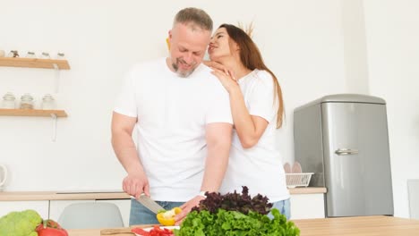 attractive husband of the european appearance of his wife in a modern kitchen attractive husband of the european appearance of his wife in a modern kitchen couple in love at home family look