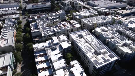 flying above large pasadena apartment complex with solar panel rooftops aerial view