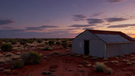 outback shed in arid landscape at sunset
