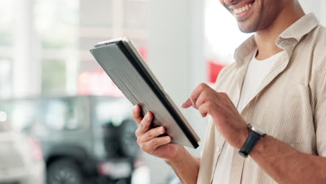 man using tablet in car dealership