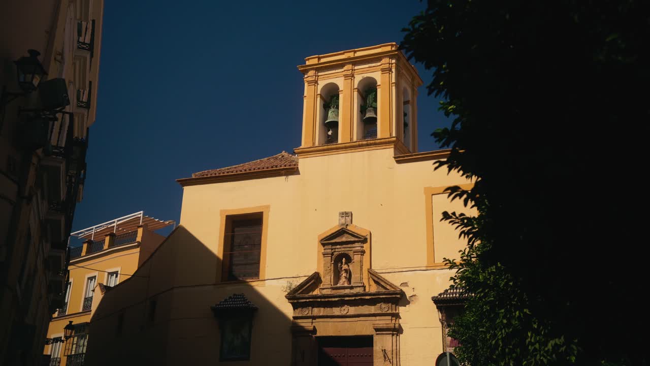 Piccola cappella storica con campanile in una strada urbana.
