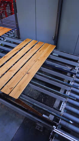 process of making parquet boards indoors. modern industrial factory for producing wooden laminate. production of panels for flooring. vertical video