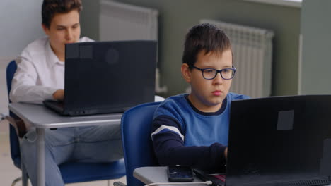 students working on laptops in classroom