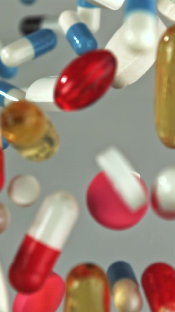 Close-up of Various Pills and Capsules Falling in Slow Motion