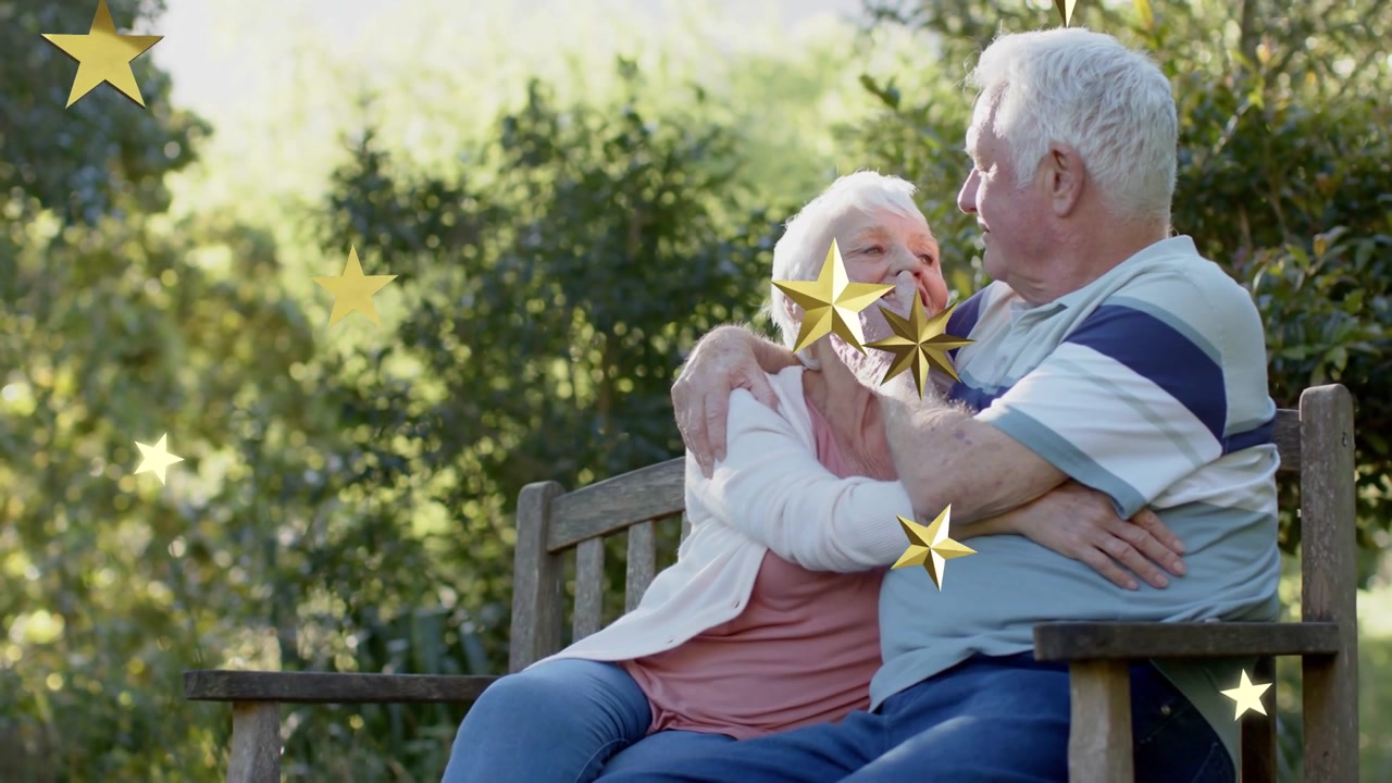 Coppia anziana su una panchina, l'uomo accarezza la guancia, mentre stelle dorate fluttuano dall'inquadratura, promuovendo la salute.