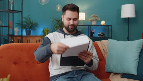 young man freelancer work with documents from home analyzing information prepare financial report