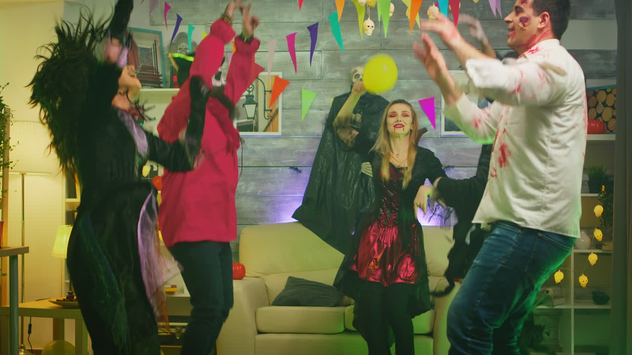 grupo emocionado de personas vestidas para halloween en diferentes personajes bailando y divirtiéndose en la fiesta de la casa