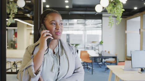 Fröhliche-Afroamerikanische-Geschäftsfrau,-Die-Im-Büro-Auf-Dem-Smartphone-Spricht,-Zeitlupe