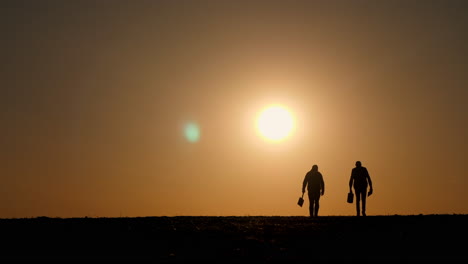 two people walking at sunset