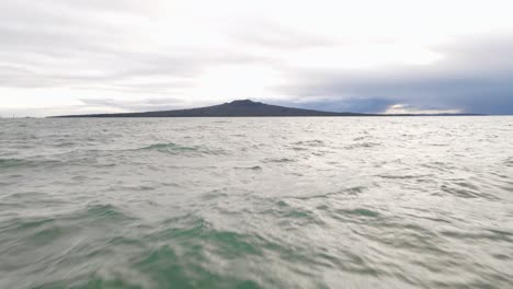 Schnelle-Und-Niedrige-Luftannäherung-Von-Einem-Strand-In-Richtung-Rangitoto-Island-Während-Eines-Bewölkten-Sonnenaufgangs