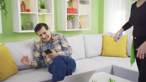 a cleaning addicted woman gets angry when she sees her husband sitting comfortably and forces her husband to clean.