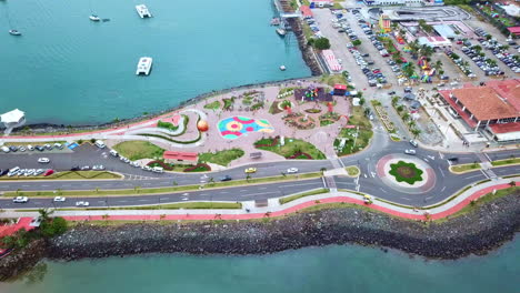 toma aérea del parque de juegos con la gente y se inclina hacia el mar y la ciudad en el fondo