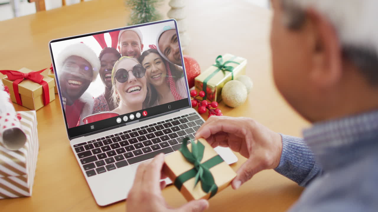 un hombre de dos razas tiene una videoconferencia de navidad con personas diversas.