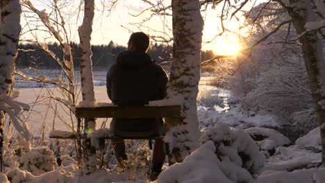 senderismo hombre viendo la puesta de sol en el paisaje de invierno