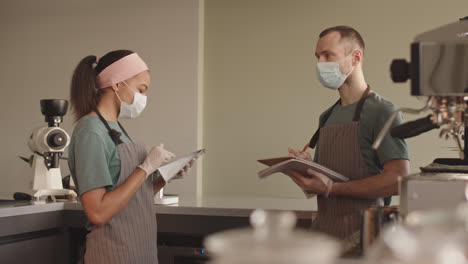 two bartenders keeping records of coffee packs