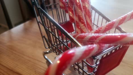 small shopping trolley filled with christmas candy canes home delivery concept kitchen idea rotate right