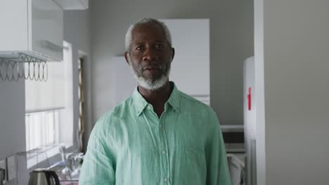 un anciano afroamericano sonriendo a la cámara y bebiendo una bebida en distanciamiento social