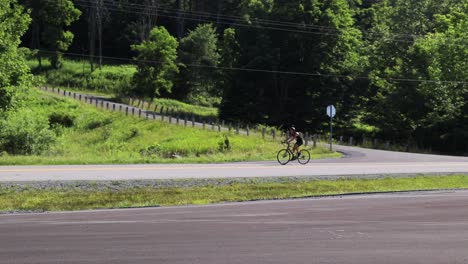 cyclist riding racing bike downhill on two-lane road on sunny day hd 60p