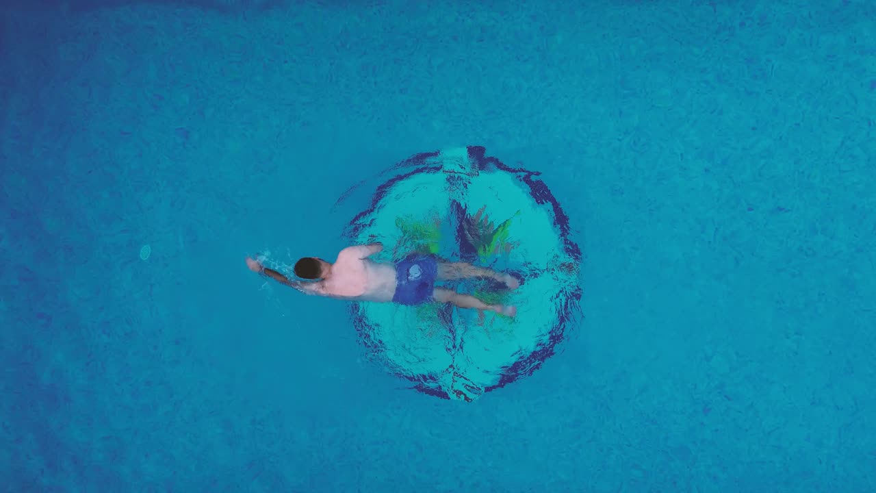 Mother and son family swimming at pool aerial view