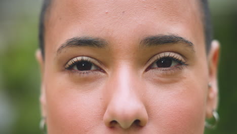 close-up of young woman's eyes, expressing calm and confidence outdoors