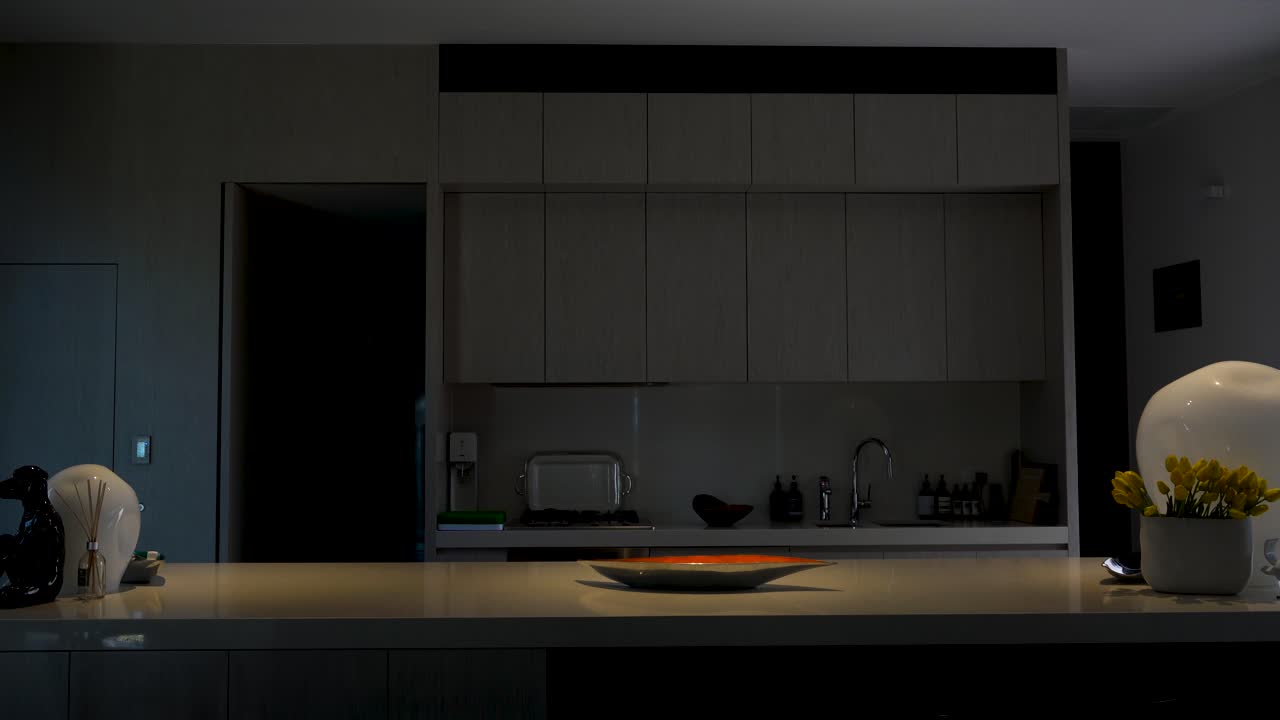 Ripresa di una cucina di lusso con illuminazione smart, le luci si intensificano.