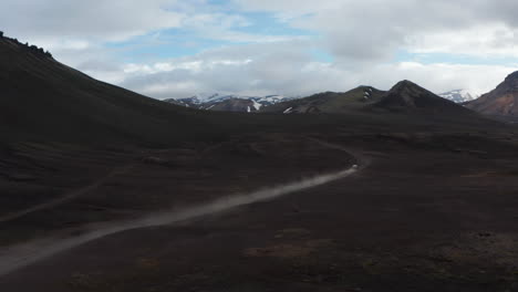 Top-view-of-Skaftafell-national-park-in-Iceland,-with-glacier-lake-and-snowy-high-mountains-peak-with-car-driving-fast-offroad.-Drone-view-of-spectacular-icelandic-highlands.-Travel-destination