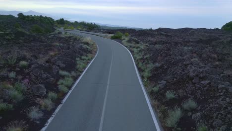 road surrounded by volcanic landscape etna sicily, damaged asphalt strip