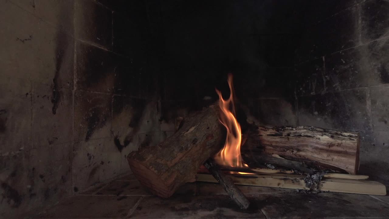 Cozy rustic fireplace with burning wood and glowing embers. Homey atmosphere. Argentina.