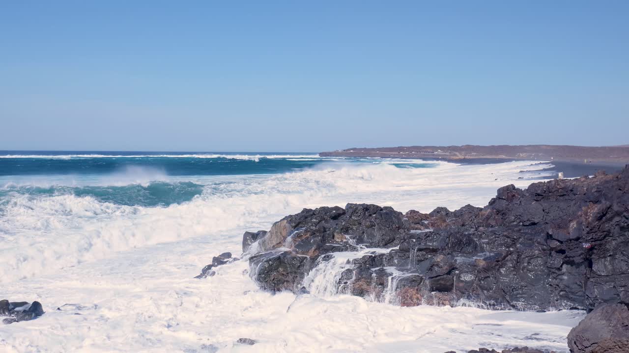 강력한 파도가 화산 해안선에 부히고