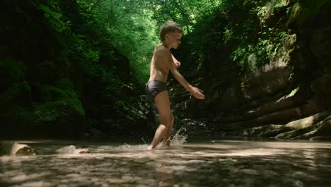 boy playing in a mountain stream