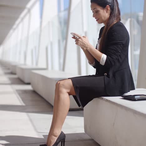 Elegant-businesswoman-reading-her-text-messages