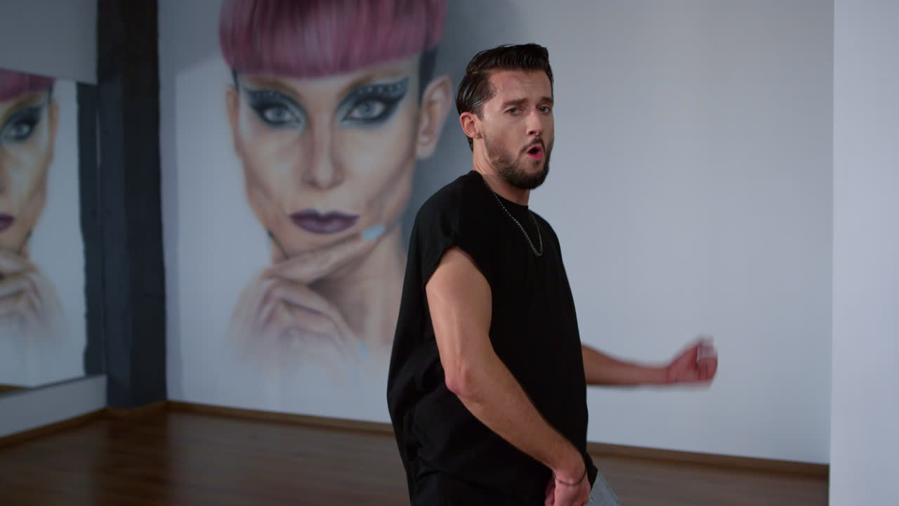 bailarina de calle buscando cámara en clase moderna. hombre feliz bailando en el interior.