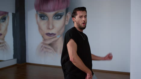 bailarina de calle buscando cámara en clase moderna. hombre feliz bailando en el interior.
