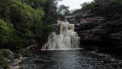 toma aérea de la impresionante cascada del pozo del diablo rodeada de rocas y follaje selvático en el hermoso parque nacional chapada diamantina en el noreste de brasil en un día nublado